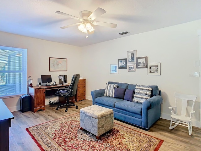 office area featuring baseboards, visible vents, ceiling fan, and light wood finished floors