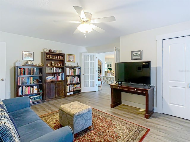 living area featuring a ceiling fan, wood finished floors, and french doors