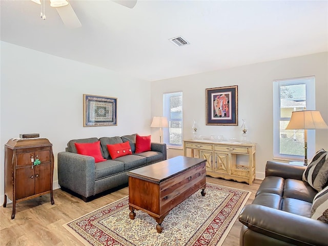 living room featuring a wealth of natural light, ceiling fan, light wood-style flooring, and visible vents