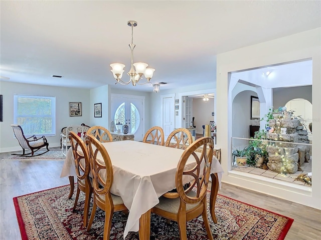 dining room with visible vents, baseboards, wood finished floors, an inviting chandelier, and french doors