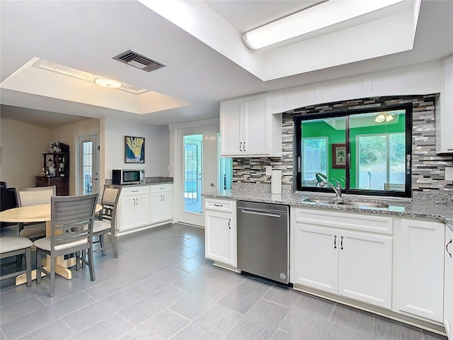 kitchen featuring tasteful backsplash, visible vents, appliances with stainless steel finishes, a tray ceiling, and a sink