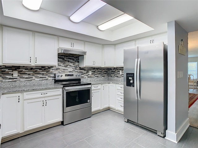 kitchen with stainless steel appliances, backsplash, white cabinetry, light stone countertops, and under cabinet range hood