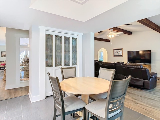 dining area with lofted ceiling with beams, wood finished floors, arched walkways, and visible vents