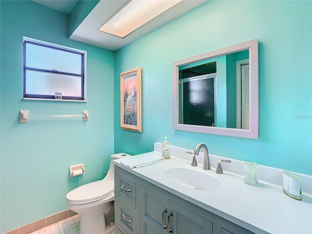 bathroom featuring toilet, a stall shower, tile patterned flooring, and vanity