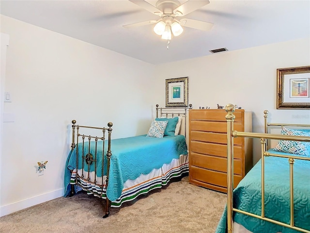 carpeted bedroom with a ceiling fan, visible vents, and baseboards