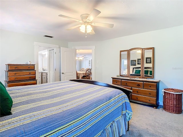 bedroom featuring carpet, visible vents, connected bathroom, and ceiling fan with notable chandelier