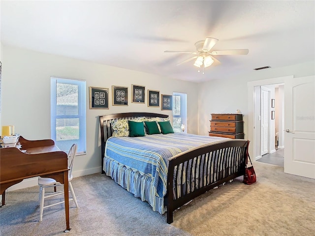 bedroom featuring baseboards, carpet flooring, visible vents, and a ceiling fan