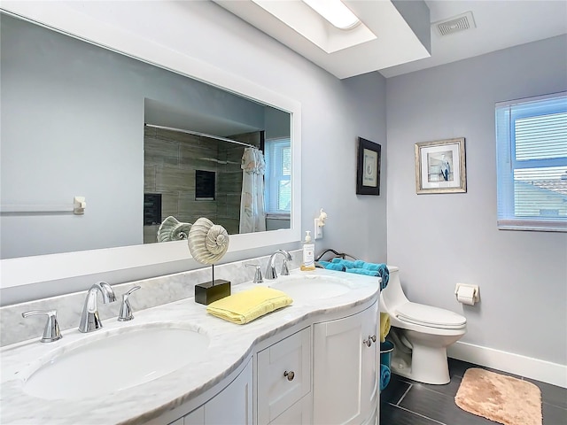 bathroom with toilet, a sink, visible vents, and baseboards