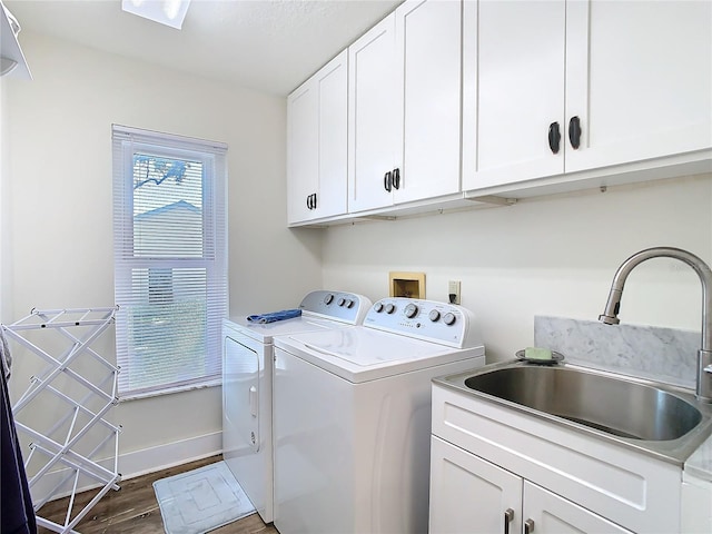 washroom with separate washer and dryer, dark wood-type flooring, a sink, baseboards, and cabinet space