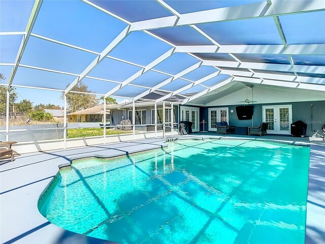 outdoor pool with a lanai, a patio area, and french doors