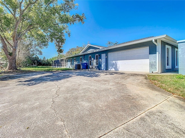 view of home's exterior featuring driveway, central AC unit, and an attached garage