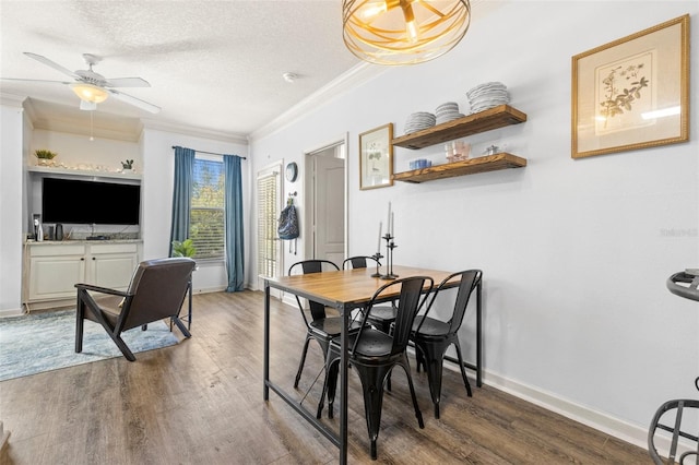 dining space with crown molding, baseboards, wood finished floors, a textured ceiling, and a ceiling fan