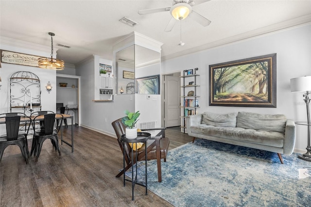 living room featuring visible vents, crown molding, and wood finished floors