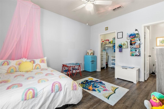 bedroom with visible vents, a walk in closet, wood finished floors, a closet, and ceiling fan