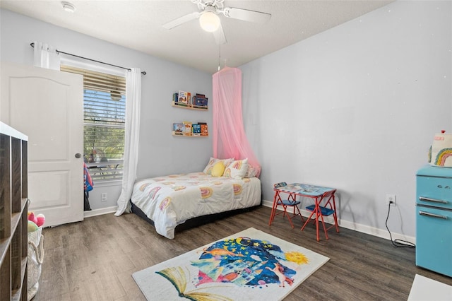 bedroom featuring wood finished floors, baseboards, and ceiling fan