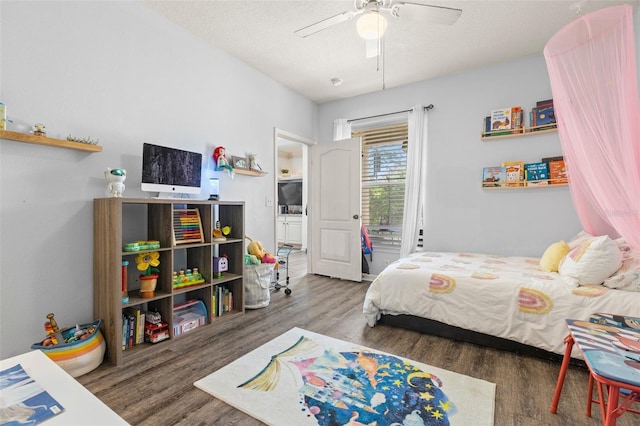 bedroom featuring a ceiling fan, wood finished floors, and a textured ceiling