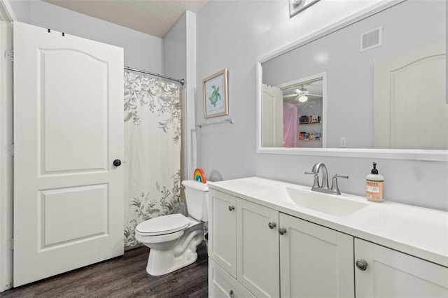 bathroom featuring visible vents, toilet, wood finished floors, and vanity