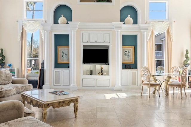 living area with a decorative wall, plenty of natural light, and light tile patterned floors