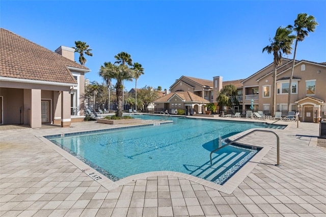 community pool featuring a patio and fence