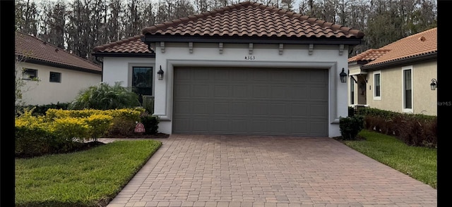 mediterranean / spanish-style house featuring a garage, decorative driveway, and stucco siding