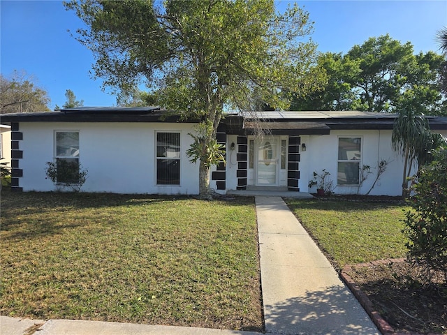 view of front of property with stucco siding and a front lawn