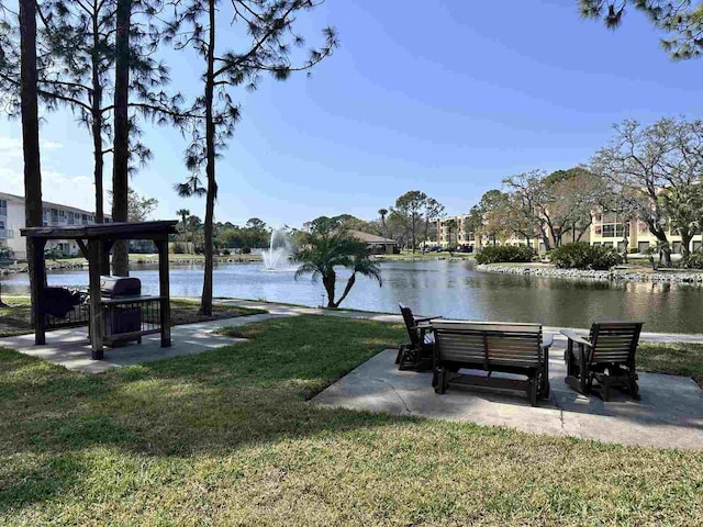 view of property's community with a water view and a yard