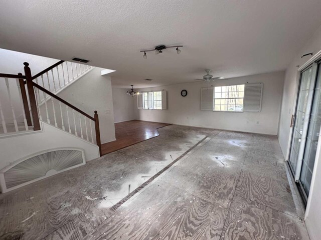 interior space featuring stairs, a textured ceiling, visible vents, and a healthy amount of sunlight