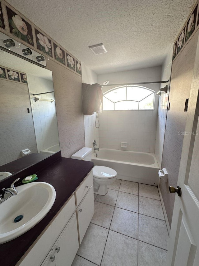 bathroom with toilet, tub / shower combination, a textured ceiling, vanity, and tile patterned flooring