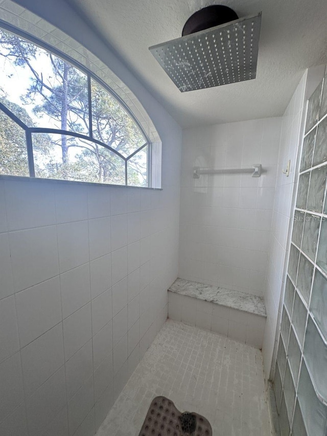 bathroom featuring tiled shower and a textured ceiling