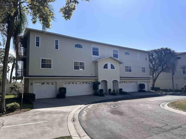 8158 Eagles Park Dr N, Saint Petersburg, FL 33709 - view of front of house with an attached garage, driveway, and stucco siding