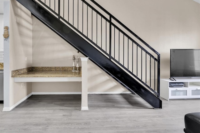 stairway with baseboards and wood finished floors