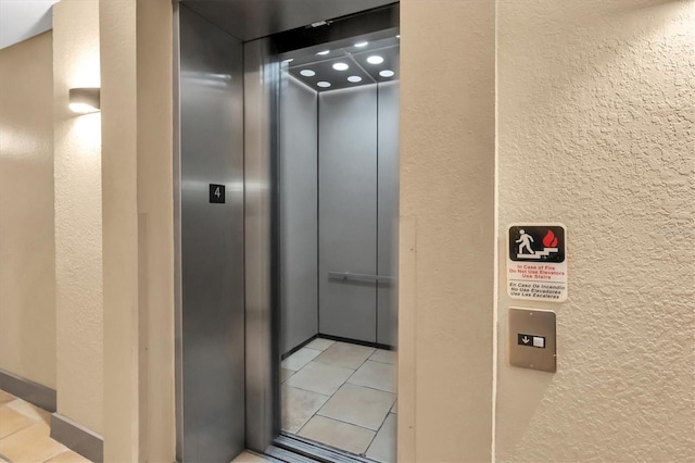 interior space featuring elevator and a textured wall