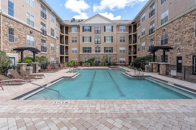 pool featuring fence and a patio