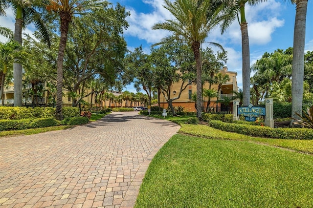 view of property's community with driveway and a yard