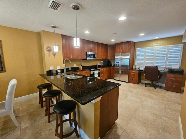 530 Sandy Hook Rd, Treasure Island, FL 33706 - kitchen with visible vents, a sink, appliances with stainless steel finishes, a kitchen bar, and a peninsula