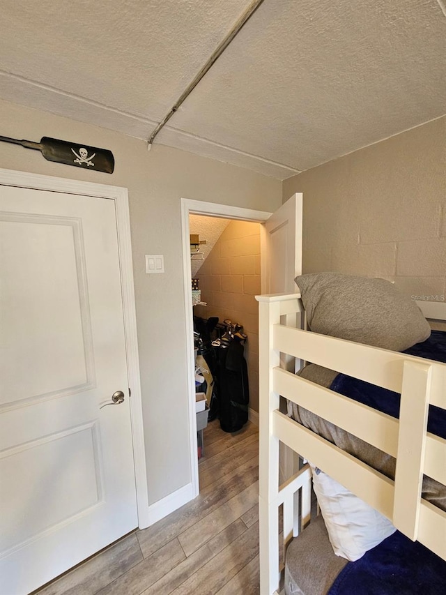 530 Sandy Hook Rd, Treasure Island, FL 33706 - bedroom with light wood-style flooring, concrete block wall, and a textured ceiling