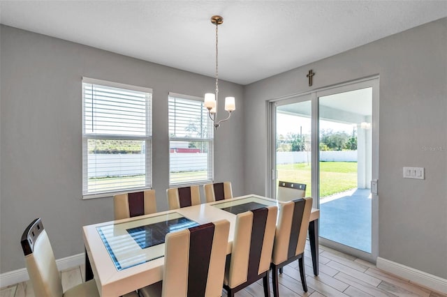 dining area with baseboards and a notable chandelier