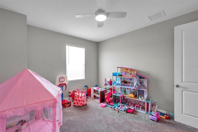 rec room featuring baseboards, visible vents, ceiling fan, carpet, and a textured ceiling