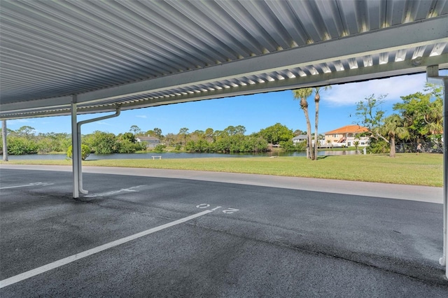 covered parking lot featuring a water view