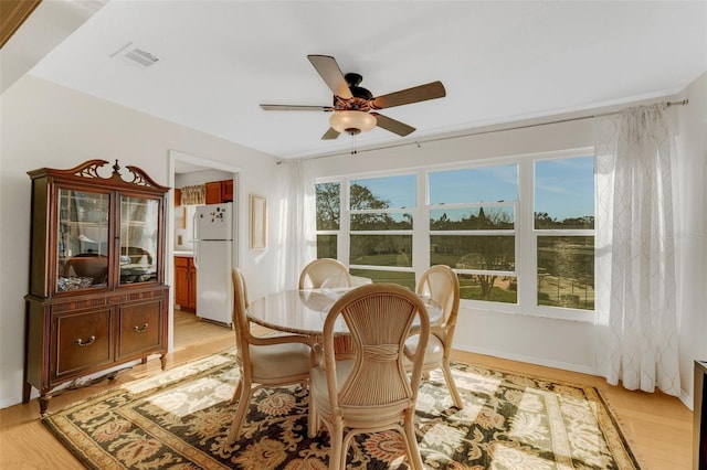 dining space featuring light wood-type flooring, visible vents, and a ceiling fan