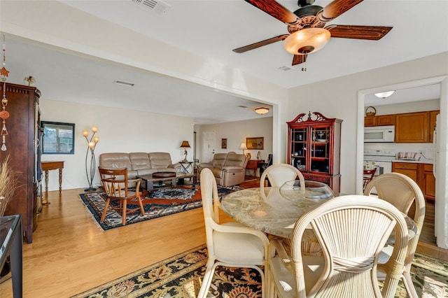 dining space with ceiling fan, light wood-style flooring, and visible vents