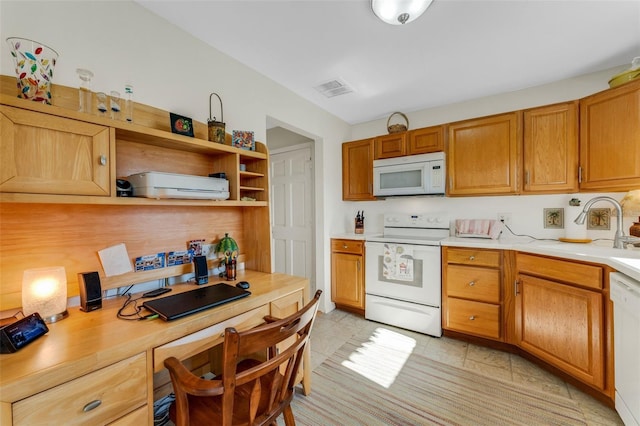 kitchen featuring white appliances, visible vents, built in study area, light countertops, and a sink