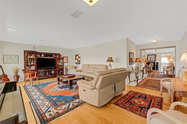 living area with light wood-style floors and visible vents