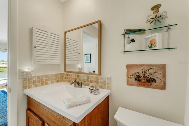 bathroom featuring tasteful backsplash, vanity, and toilet