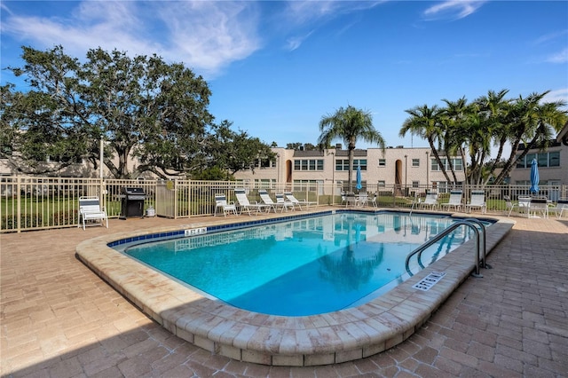 community pool featuring a patio and fence