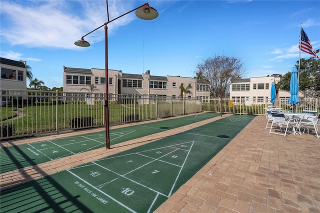 view of property's community with fence and shuffleboard