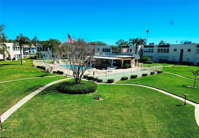 view of property's community featuring fence and a yard