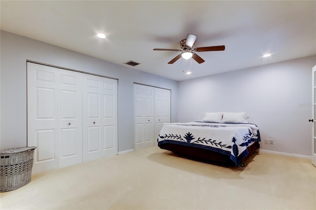 bedroom with multiple closets, recessed lighting, visible vents, carpet flooring, and baseboards