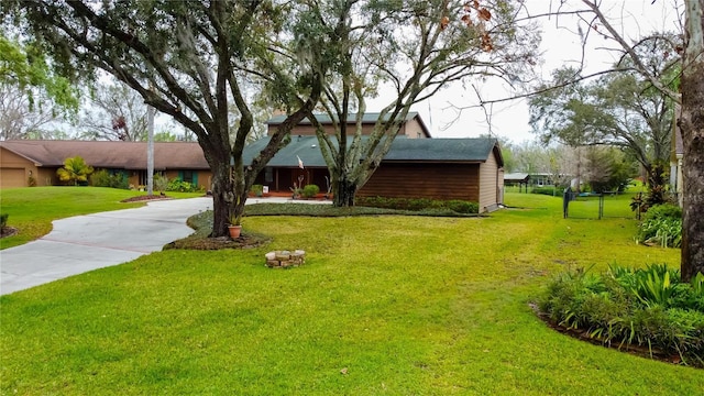 view of front of home with concrete driveway, a front lawn, and fence