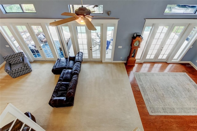 living room featuring a healthy amount of sunlight, wood finished floors, and french doors